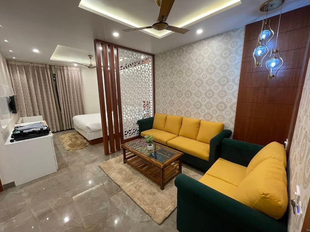 Luxury suite with yellow sofa and elegant wooden partition at Sujata Hotel Varanasi